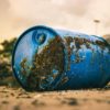 blue plastic barrel with mud on the ground